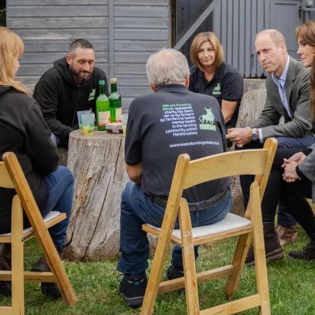 The Prince and Princess of Wales sitting around a table with We Are Farming Minds representatives