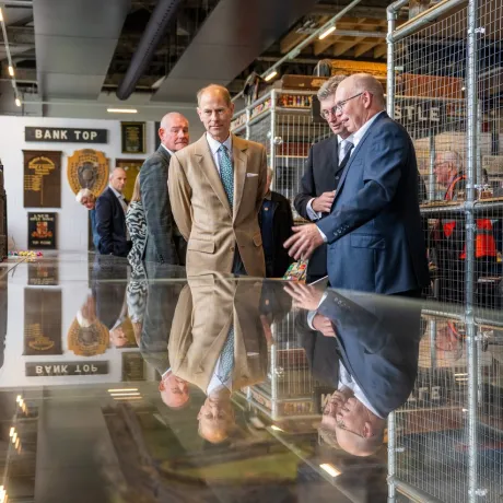 The Duke of Edinburgh looks at artefacts in a museum