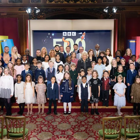 The Queen smiles alongside 500 Words finalists