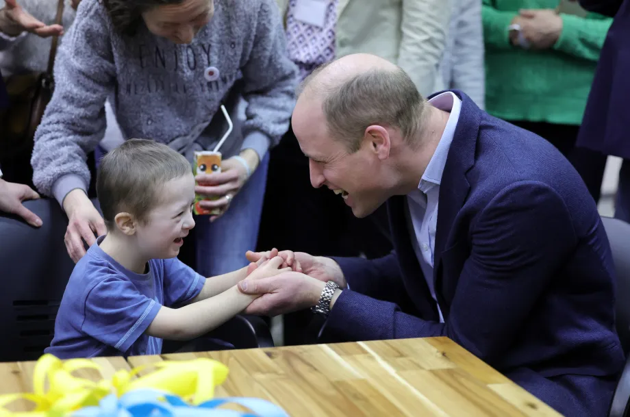 The Prince of Wales laughs with a child at an accommodation centre for Ukrainian families