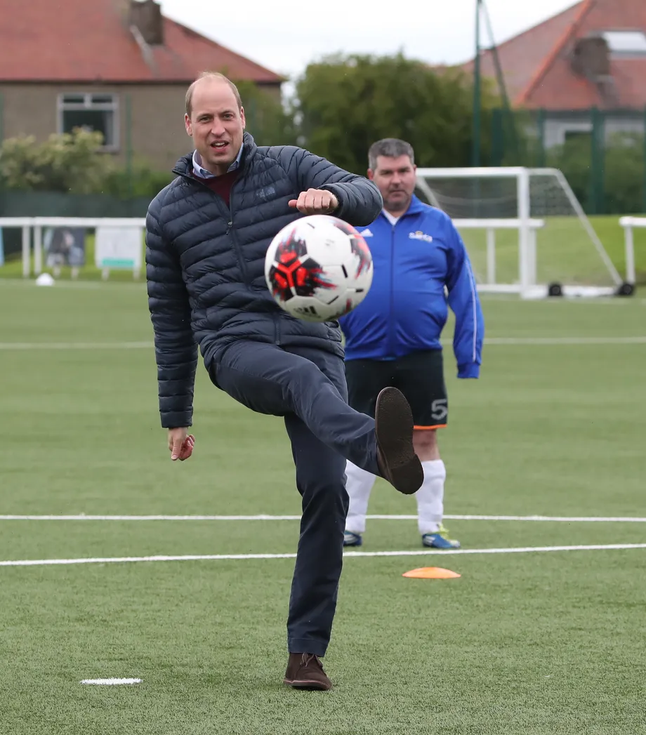 The Prince of Wales kicks a ball during a visit to Spartans FC's Ainslie Park Stadium in Edinburgh