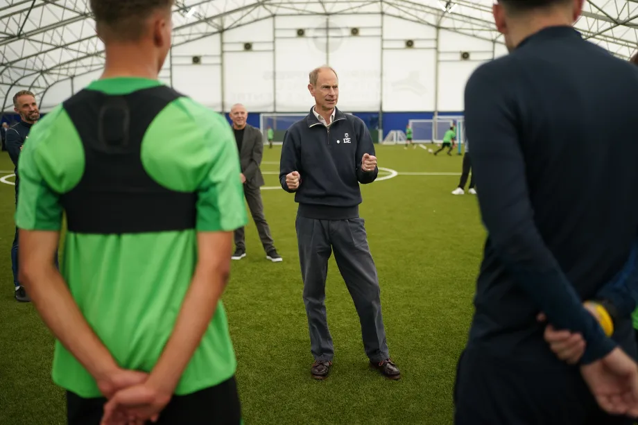 The Duke of Edinburgh talks to students in a football training session