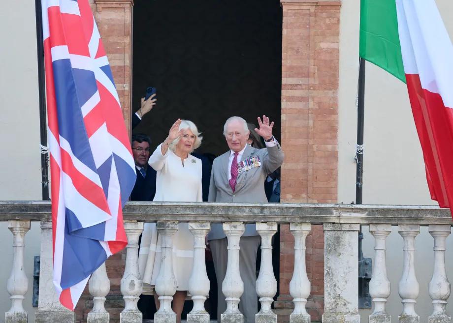 Their Majesties wave from a balcony during a visit to Emilia-Romagna Food Festival
