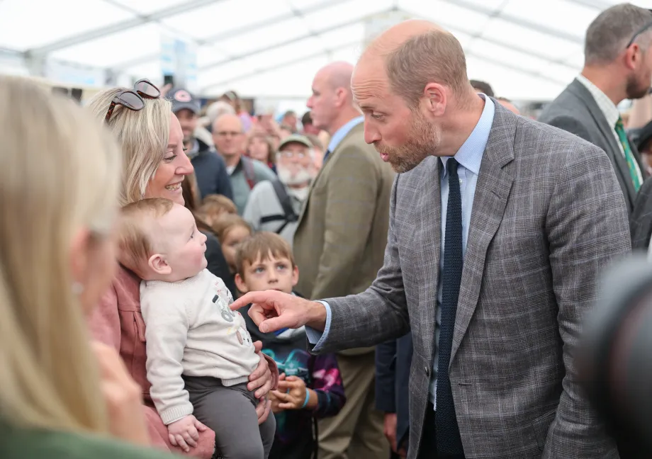 The Prince of Wales speaks with a mother and baby at the Royal Cornwall Show