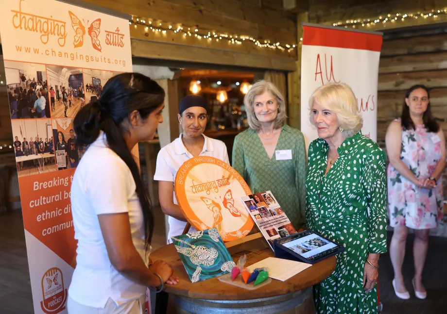 The Queen speaks to staff members of "Changing Suits", which works with South Asian communities to overcome cultural barriers, during a visit to Wiltshire Community Foundation