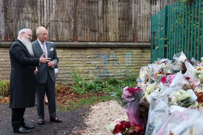 The King, alongside Rabbi Daniel Walker, look at floral tributes 
