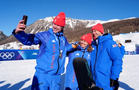 The Duke of Edinburgh smiles for a photo with Team GB athletes Charlotte Bankes and Huw Nightingale