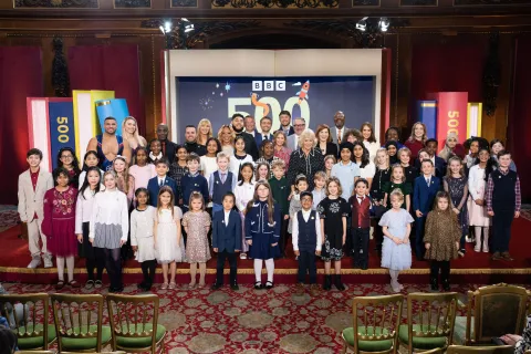 The Queen smiles alongside 500 Words finalists